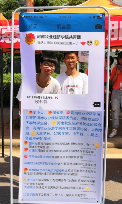 新生在迎新朋友圈展板前合影留念